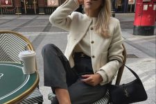 an old money look with a white jumper and cropped blazer, grey trousers, black slingbacks and a small ba