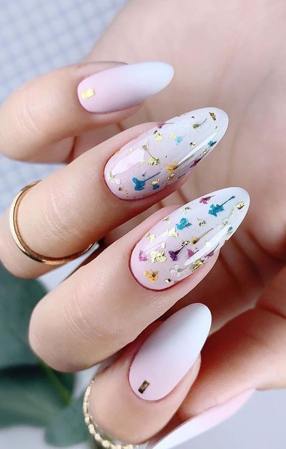 an ombre manicure with matter and glossy nails and glossy ones are accented with gold leaf and colorful dried flowers