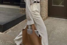an oversized white shirt, creamy high waisted pants, black shoes, a beige tote and a black belt
