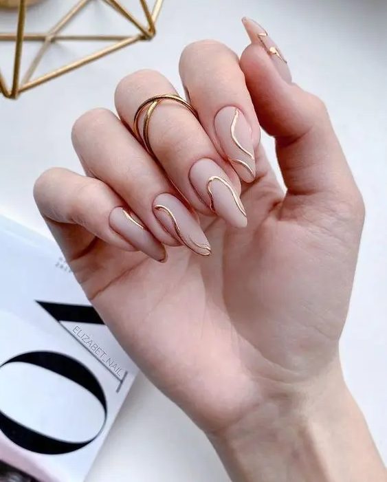 an ultra-modern wedding manicure with matte nude nails and gold abstract lines is a catchy idea for a modern and stylish look