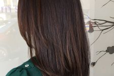 beautiful dark brown medium-length hair with layers and slight dark chestnut balayage is a stylisha nd eye-catching idea