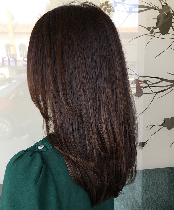 beautiful dark brown medium-length hair with layers and slight dark chestnut balayage is a stylisha nd eye-catching idea