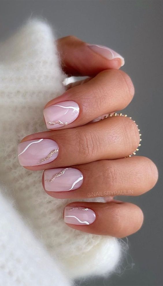 beautiful short square nails in blush pink, with abstract wavy white and gold glitter patterns are amazing for a glam look