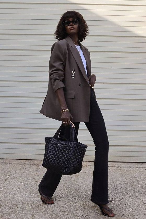 black flare jeans, a white t-shirt, a taupe oversized blazer, black shoes and a black bag