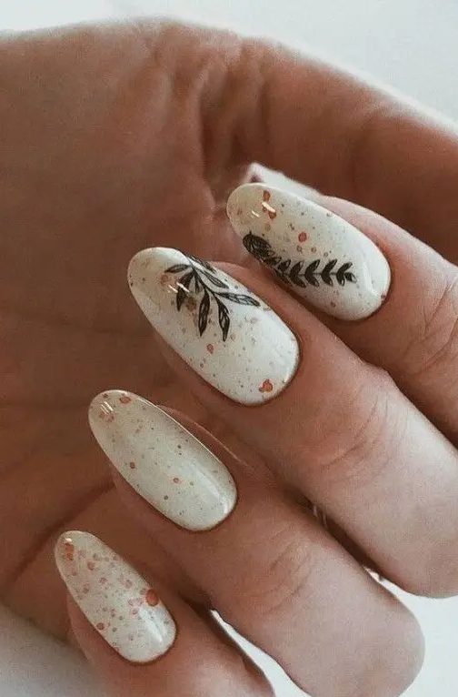 creamy boho nails with tan and red splatters and some painted leaves are adorble for spring, summer and fall looks