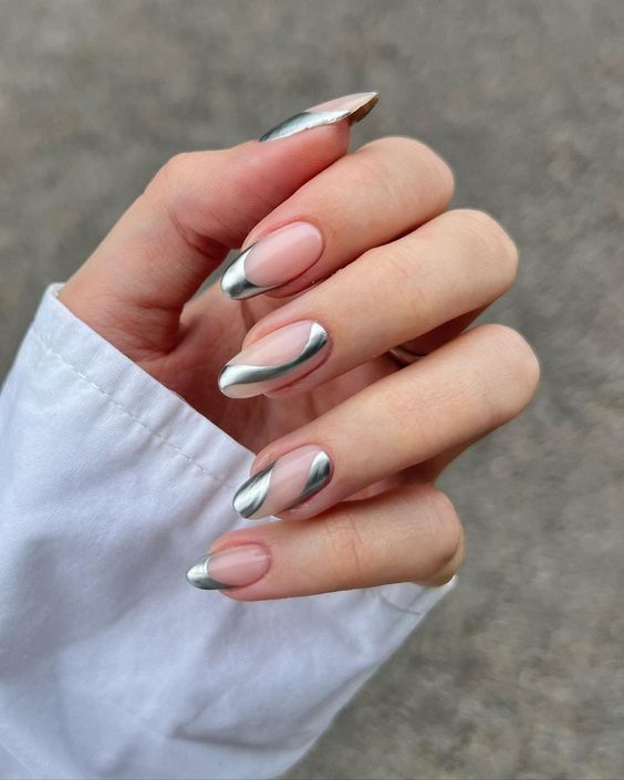 eye-catchy long almond nails with silver swirls on nude nails is adorable and looks very trendy