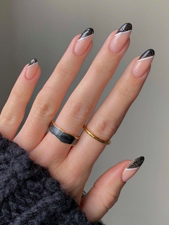 long almond-shaped nails with black glitter tips are a cool take on French manicure, they look cool