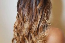 long and volumetric ombre hair from dark brunette to caramel and almost golden blonde, with waves is lovely