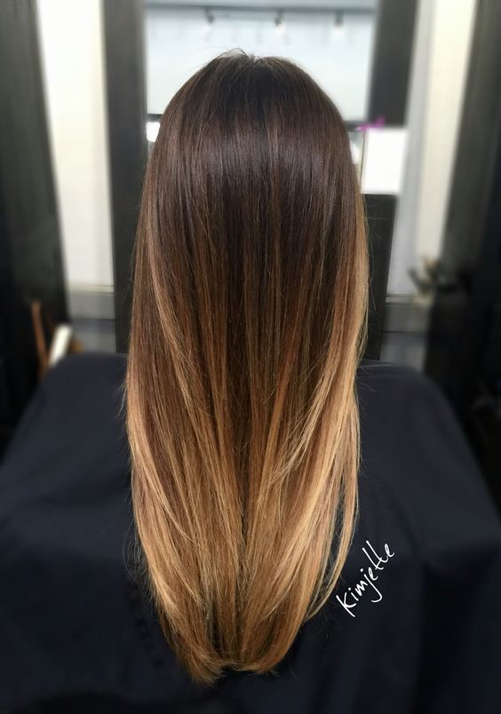 long hair from dark brunette to golden blonde ombre, with a lot of volume, looks chic, stylish and elegant