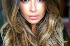 long ombre hair from black to golden blonde and bronde, with layers, waves and volume is amazing