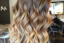 long volumetric brunette to bronde and blonde hair, with waves, is a super chic and catchy idea