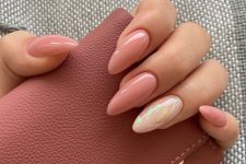 lovely long almond nauls ina  nude shade of pink, with a single accent nail done with a holograhic design