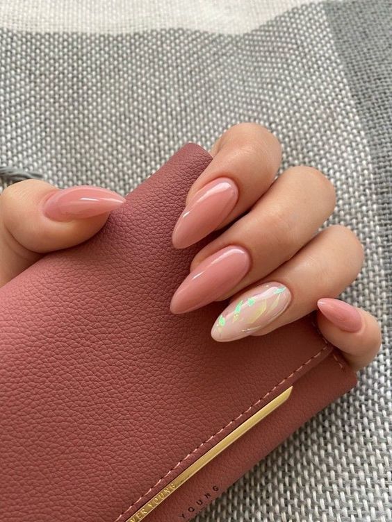 lovely long almond nauls ina  nude shade of pink, with a single accent nail done with a holograhic design