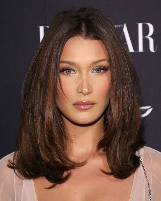 Medium length chocolate brown hair with caramel balayage and curled ends plus volume is a chic idea