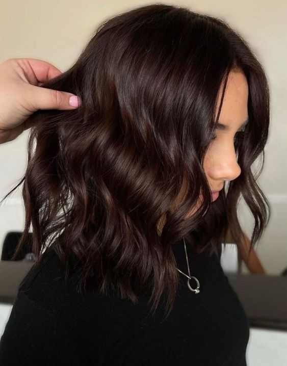medium-length dark brown hair to dark cherry hair, with waves and volume, is a stunning and catchy solution