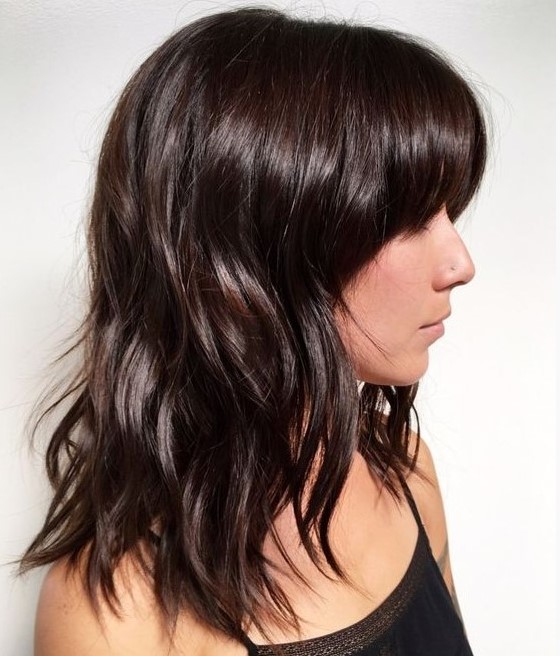 medium-length dark brown hair with waves down and some bangs is a catchy idea, add a shiny touch to the look