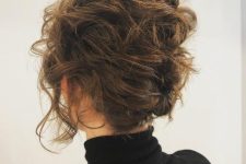naturally wavy short hair styled as an updo secured with some pins, with a wavy top and face-framing hair