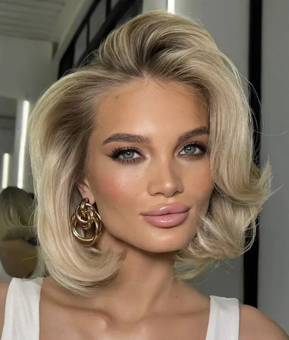 a beautiful midi blonde bob with a lot of volume and curled ends is a cool hairstyle to rock with old money looks
