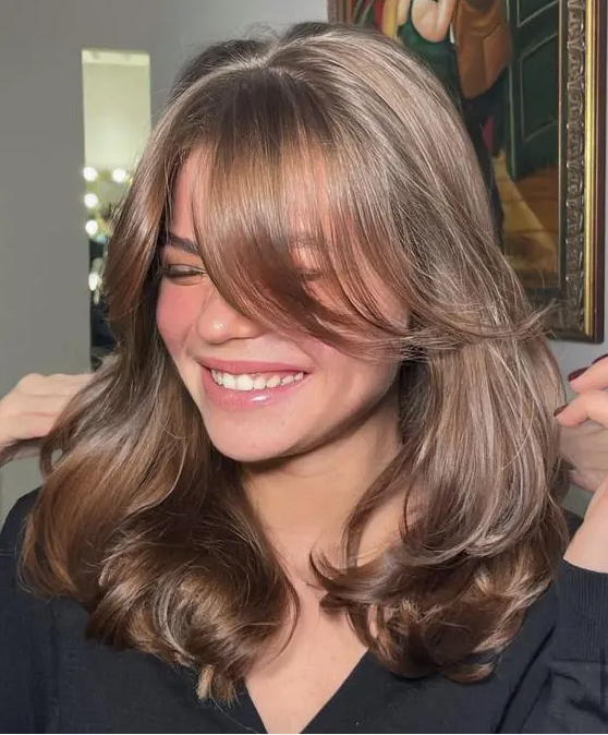 24 an elegant and shiny brown butterfly haircut with curtain bangs and a bit of waves to make it more dimensional