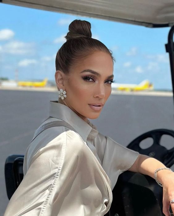 J.Lo wearing a tight top knot paired with a sleek top looks fabulous, this hairstyle works for most outfits