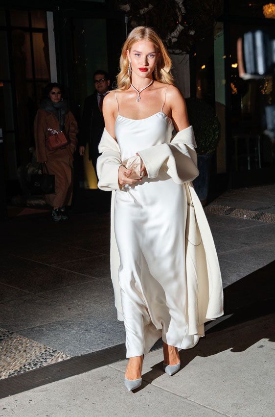 Rosie Huntington-Whiteley wearing a gorgeous outfit of a white maxi dress and a matching duster plus silver shoes and statement accessories