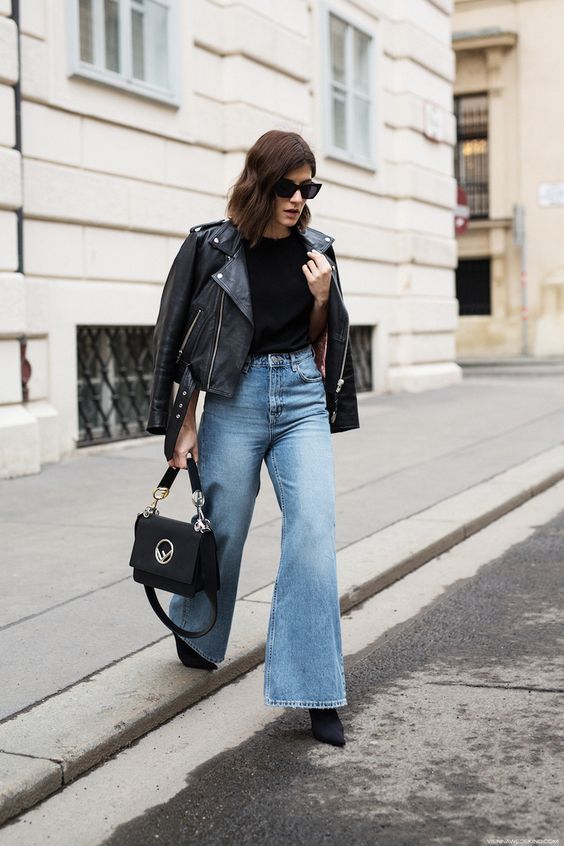 a black tee, blue flare jeans, a black leather jacket, black boots and a bag are a cool and timeless idea
