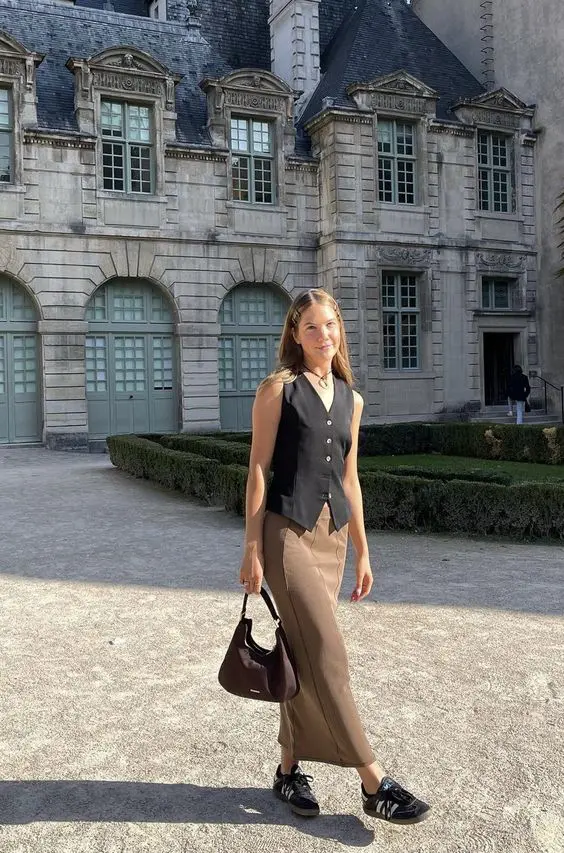 a black waistcoat, brown maxi skirt, black sneakers and a brown bag for a quick and easy look