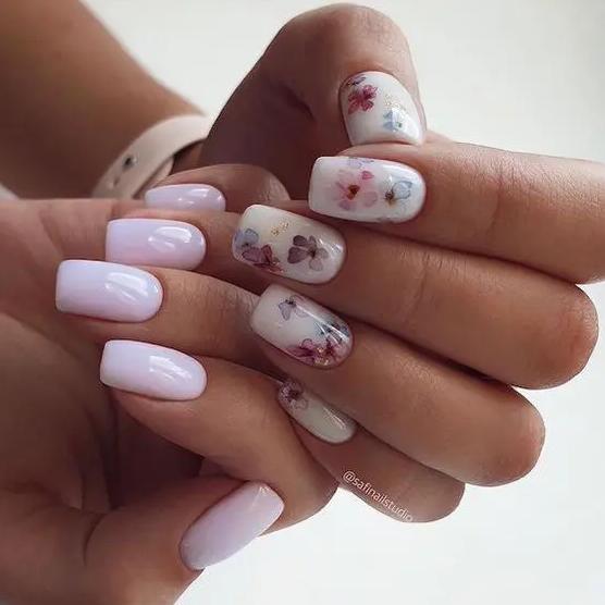 a catchy manicure with pale pink and white nails and colorful pressed blooms on one hand only will make you stand out