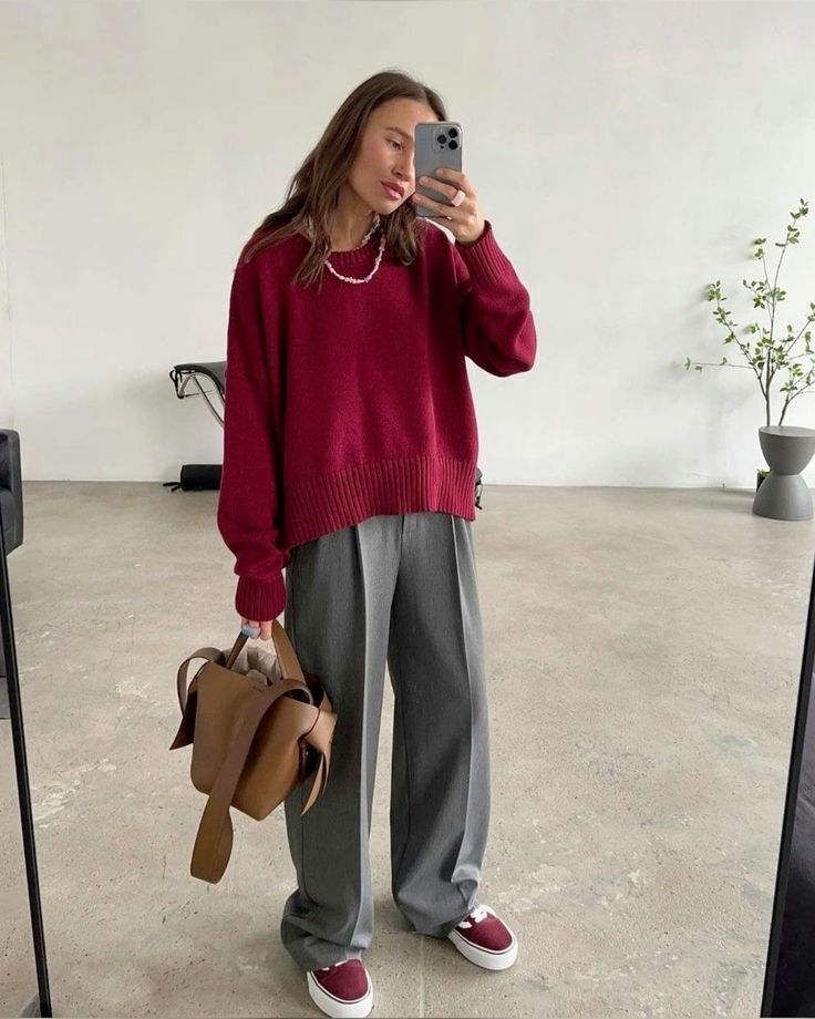 a cherry red jumper, grey trousers, cherry red sneakers, a tan bag and a necklace are a cool combo for winter
