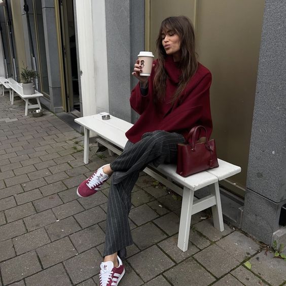 a cherry red oversized sweater, grey fine stripe trousers, cherry red sneakers and a matching bag are a cool outfit for cold days