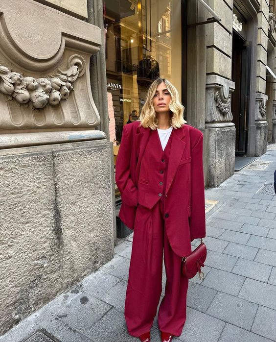 A cherry red three piece pantsuit with an oversized blazer and wideleg pants, a cherry red saddle bag and a white t shirt