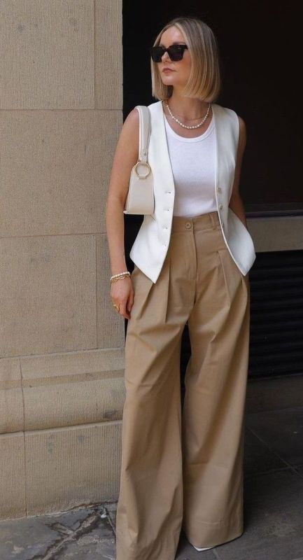 a chic summer look with a white tank top, a waistcoat, beige high-waisted pants, a creamy bag and creamy shoes