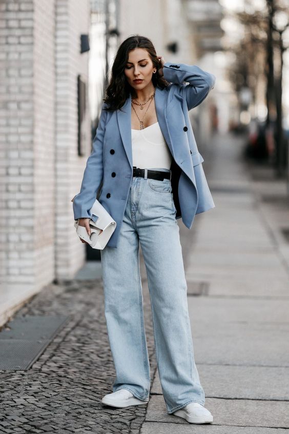 a comfortable spring look with a white bustier top, blue jeans, a blue blazer, white sneakers and a white clutch
