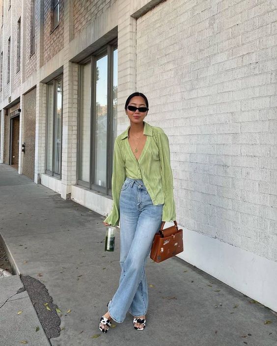 a cool spring look with a green button down, blue jeans, printed shoes, a brown bag and sunglasses is fun