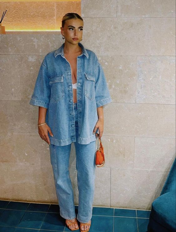 a double denim look with an oversized shirt, jeans, orange strappy shoes and a small bag is cool for spring