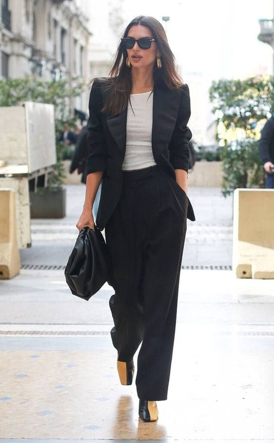 a gorgeous black pantsuit with wideleg pants and an oversized blazer, a white tee, two-tone shoes and a large bag