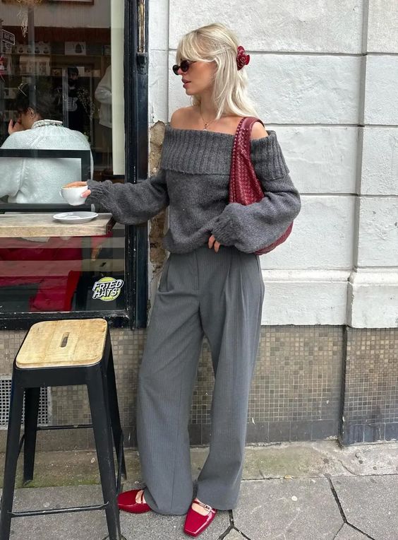 a grey off the shoulder sweater, trousers, cherry red shoes and a woven bag are a lovely and trendy outfit