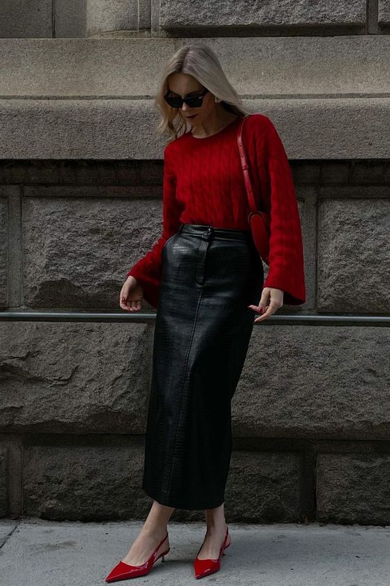 a jaw-dropping outfit with a cherry red jumper with bell sleeves, a black leather maxi skirt, red kitten heels and a cherry red bag