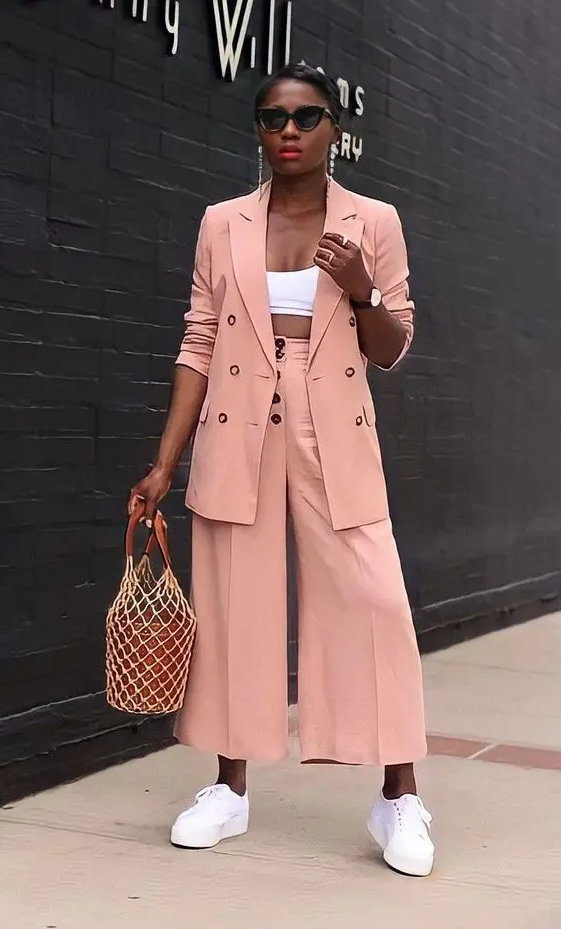 a lovely peachy pink pantsuit with culottes, an oversized blazer, a white crop top, white sneakers and a bucket bag