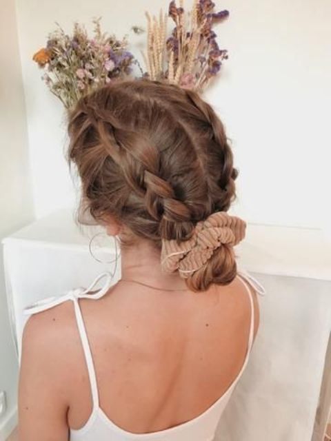 a low bun plus braids on top and a beige scrunchie is a lovely and pretty hairstyle to go for