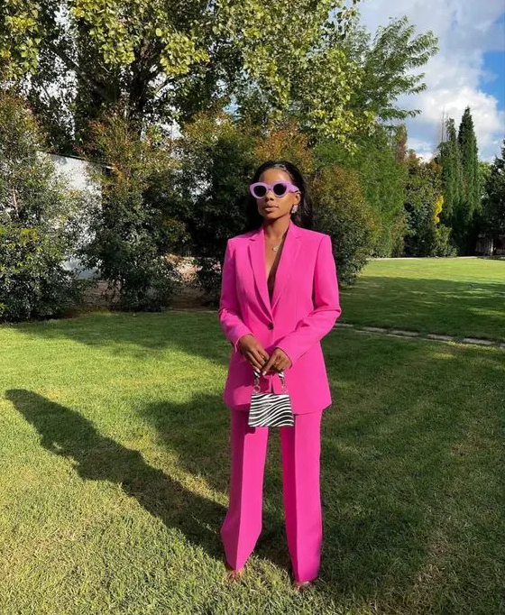 a magenta pantsuit with an oversized blazer, a printed mini bag and sunglasses in a lilac frame are a nice and bold look