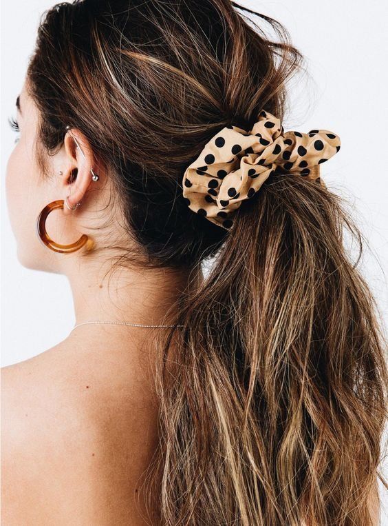 a messy low ponytail with a messy top and textured hair down plus a beige polka dot scrunchie is amazing