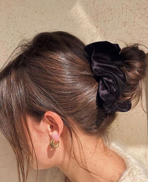 a messy midi bun with a bump on top and some face-framing hair is a lovely casual hairstyle