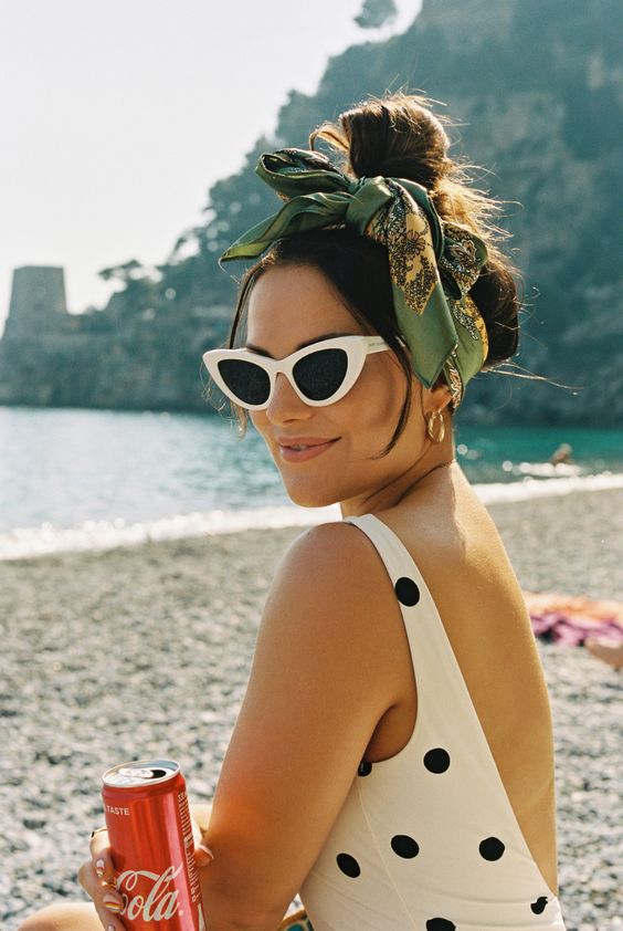 a messy top knot accented with a green scarf that is used as a bow to achieve that retro Italian look