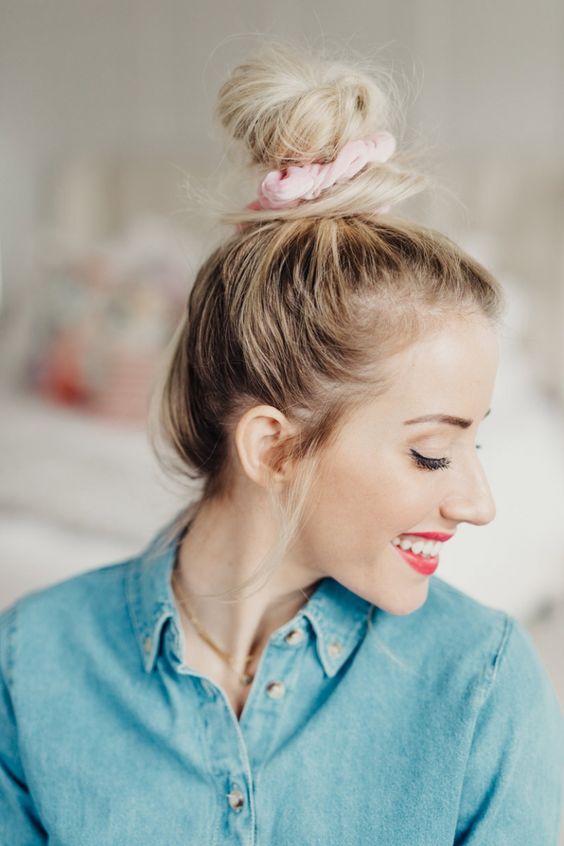 a messy top knot with a messy top and a pink scrunchie is a lovely and pretty hairstyle to make on the go