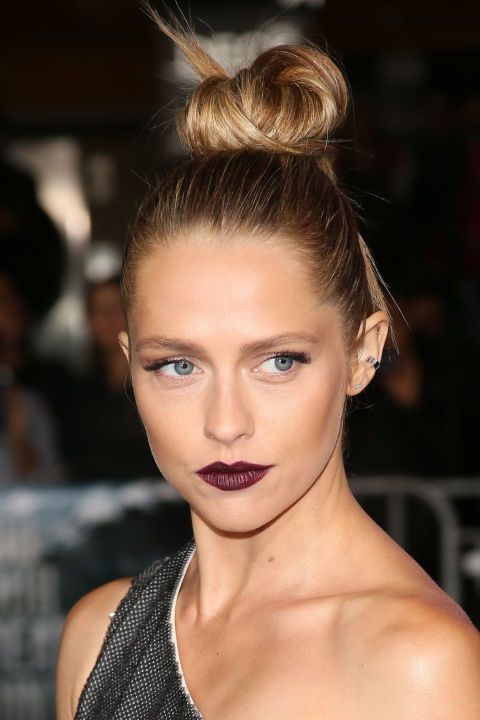 a messy wrapped top knot with some hair down and a very sleek top is a cool idea to make a statement