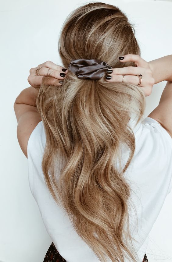 a midi ponytail with long wavy hair ad a volume on top secured with a grey silk scrunchie is amazing