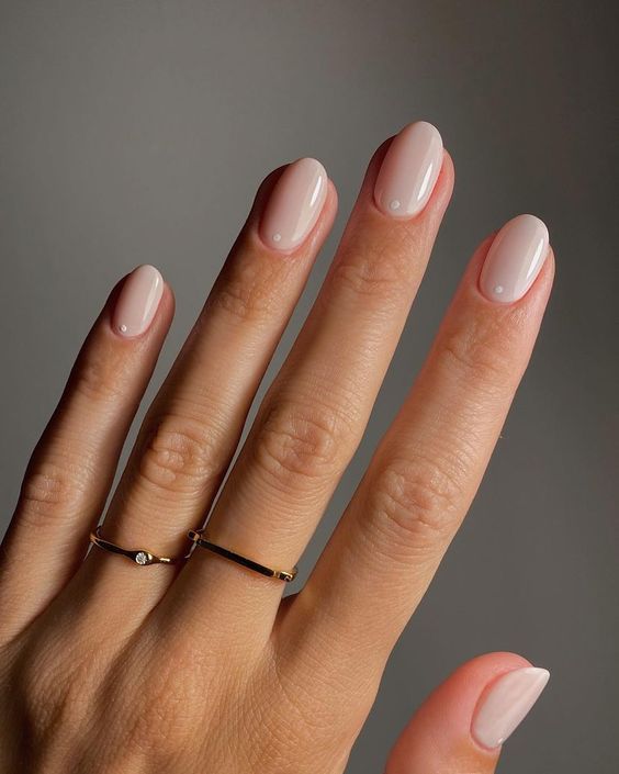 a minimalist and trendy manicure in a milky shade, with little white dots, is a lovely and tender idea for spring