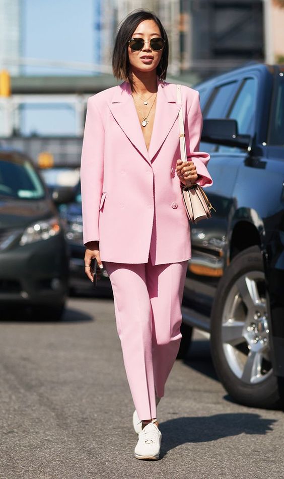 a minimalist pink power suit with an oversized blazer, white sneakers, a neutral bag and a layered necklace for a bold spring look