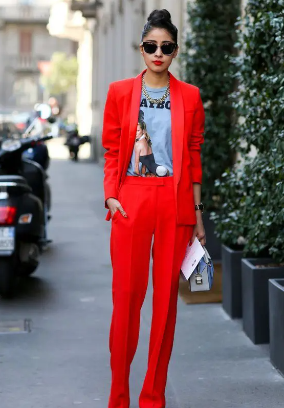 a red pantsuit with extra long pants, a printed tee, a statement necklace, a small bag for a street style look